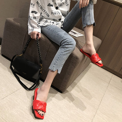 Woman wearing trendy red woven sandals, light denim jeans, and black bag, FashionRay style