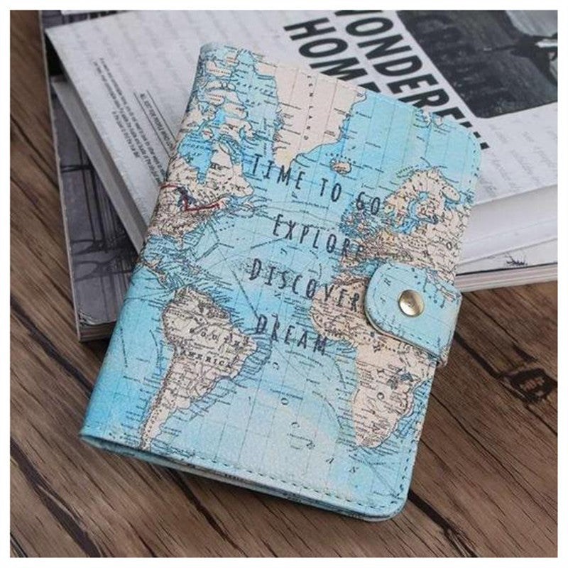 Travel-themed notebook with world map design and explore, discover, dream text on wood table