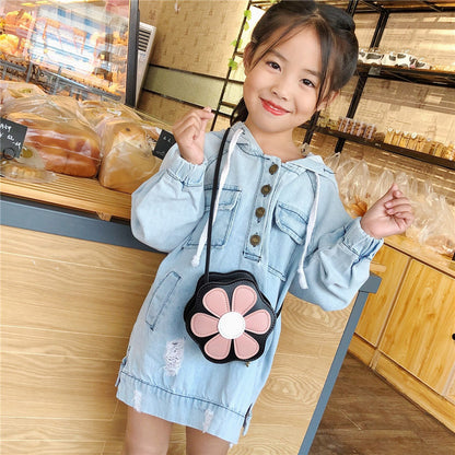 Smiling girl in a light denim dress with a flower purse at a bakery, FashionRay style