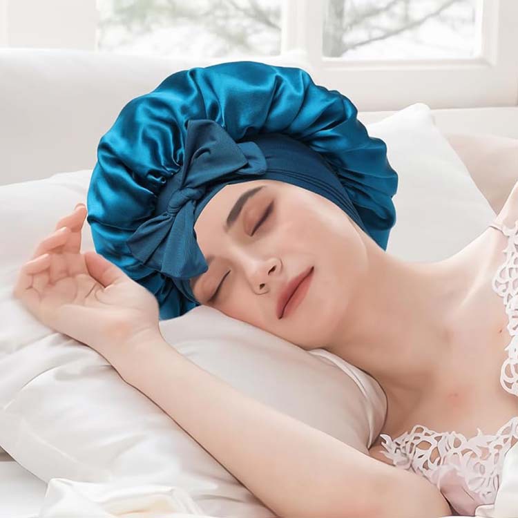 Woman sleeping on white bedding, wearing a blue satin bonnet, FashionRay comfort and style