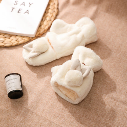Cozy white plush slippers with bunny ears and pom-poms on a beige surface, FashionRay style