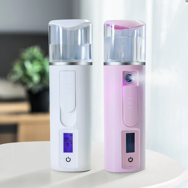 Two portable facial mist sprayers in white and pink on a table, modern home background.
