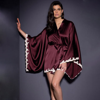 Woman modeling burgundy satin kimono robe with lace trim, stylish loungewear at FashionRay