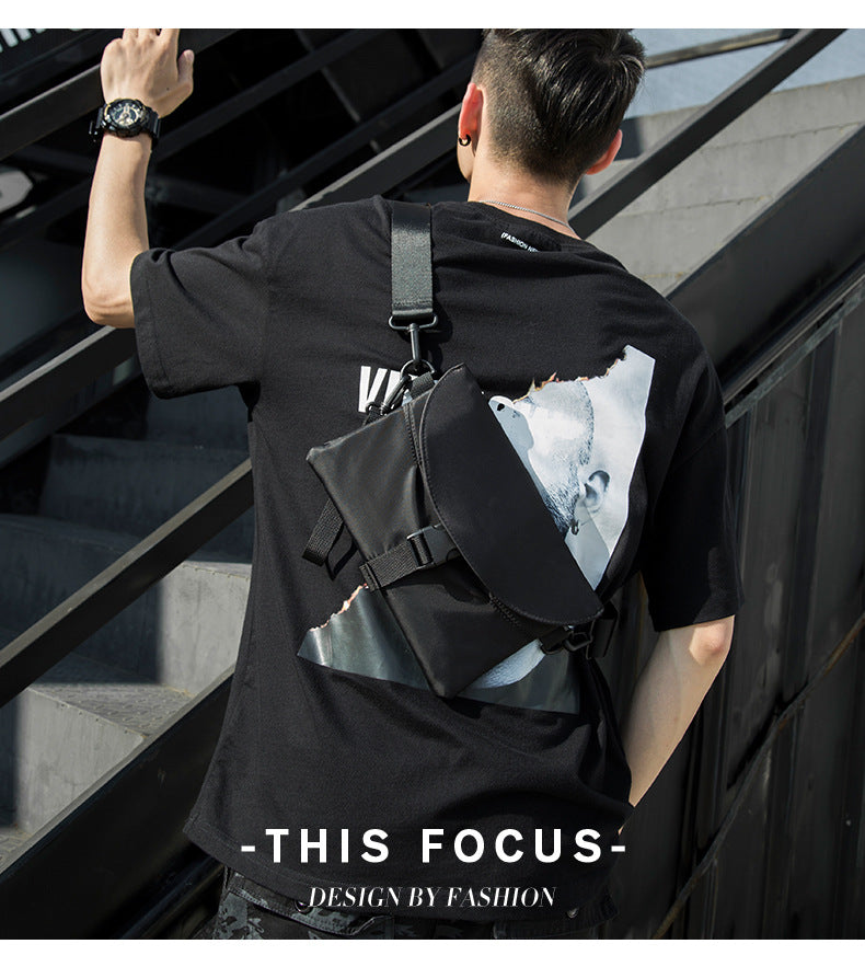FashionRay street style: man in black graphic tee and crossbody bag on modern stairs