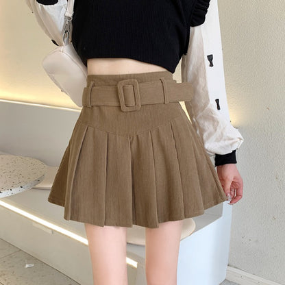 Woman wearing trendy brown pleated skirt with belt and black crop top, FashionRay style