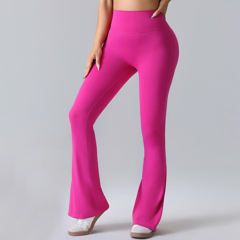 Woman modeling bright pink high-waisted flare pants from FashionRay on neutral background