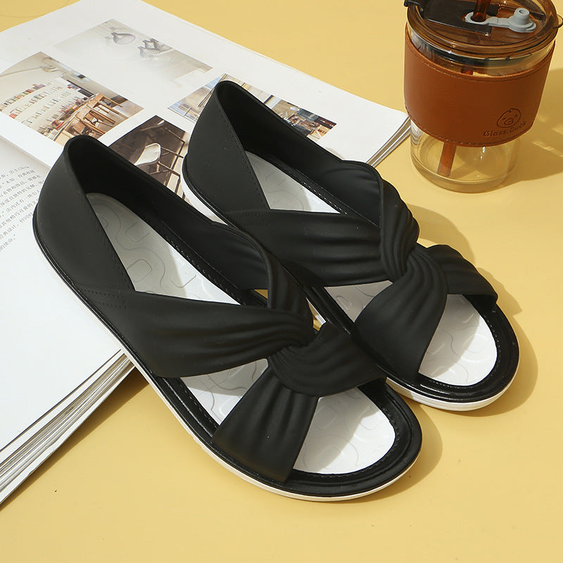 FashionRay black slip-on sandals with twisted straps on a magazine and yellow background