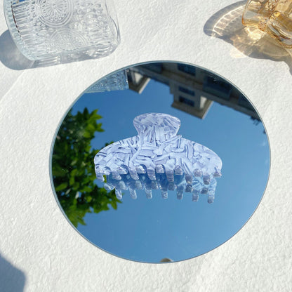 Trendy marbled hair claw clip on round mirror outdoors, FashionRay accessory flat lay