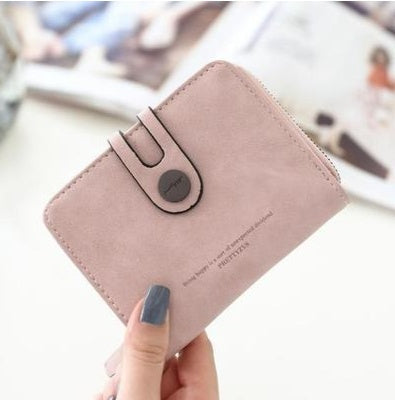 Hand holding a stylish light pink suede wallet with snap closure, FashionRay accessory