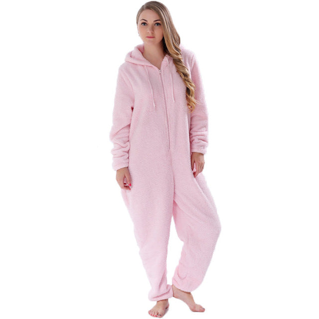 Woman wearing a pink fleece hooded onesie, cozy loungewear from FashionRay