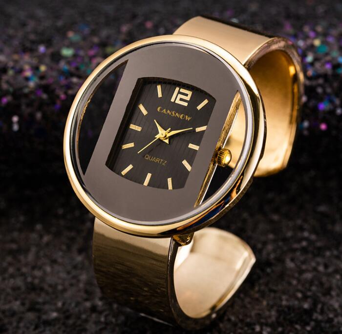 Gold women's quartz wristwatch with black face, showcased on a glittery dark background