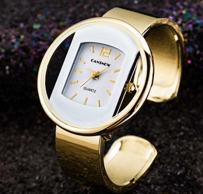 Gold oval quartz wristwatch with metallic band on dark textured background, FashionRay style