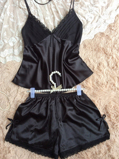Black satin camisole and shorts pajama set with lace trim from FashionRay on lace background