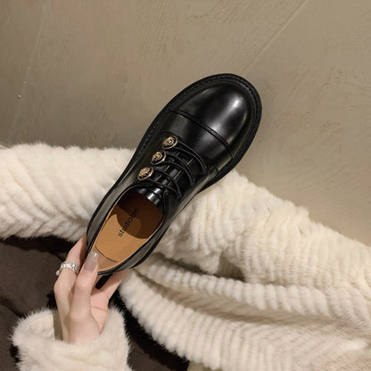 FashionRay black leather oxford shoe with gold buttons, held over a white faux fur coat