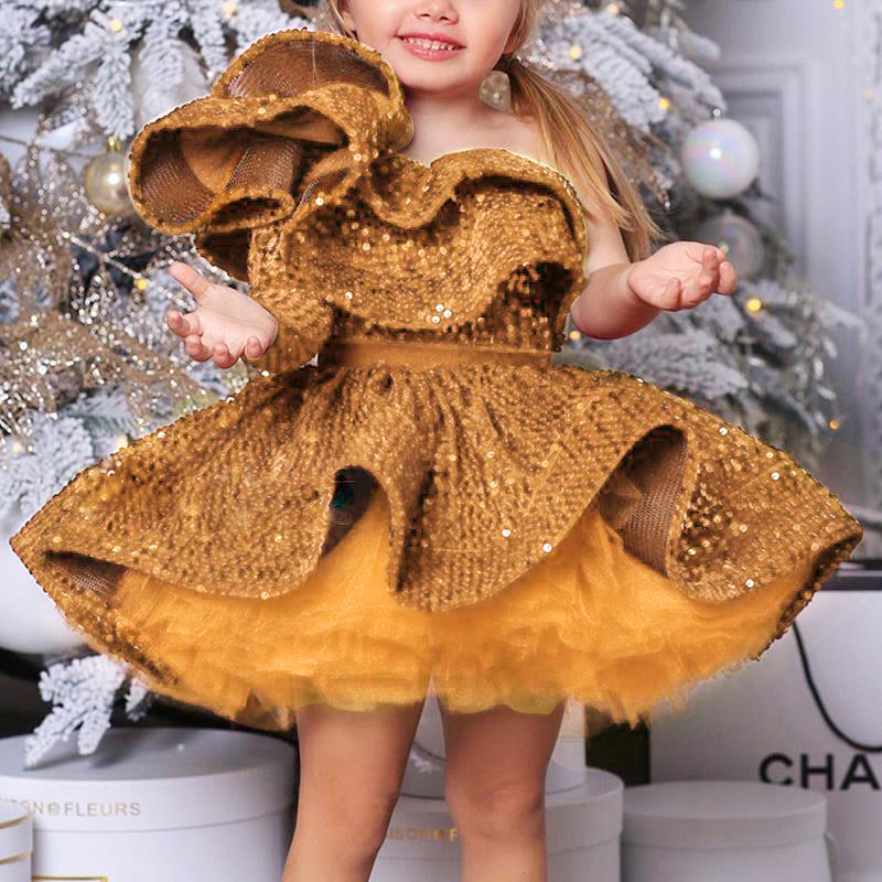 Girl in gold sequin dress smiling, festive backdrop, FashionRay trendy kids fashion