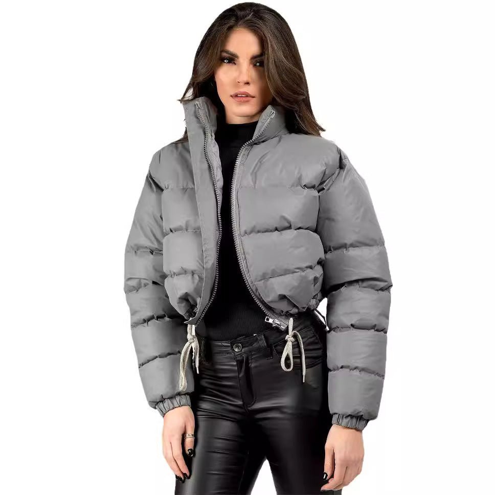 Woman in gray puffer jacket and black leather pants, trendy winter fashion by FashionRay