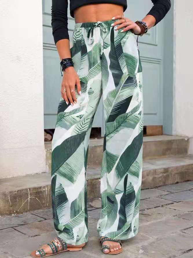 Woman wearing FashionRay green leaf print wide-leg pants and crop top, outdoor setting