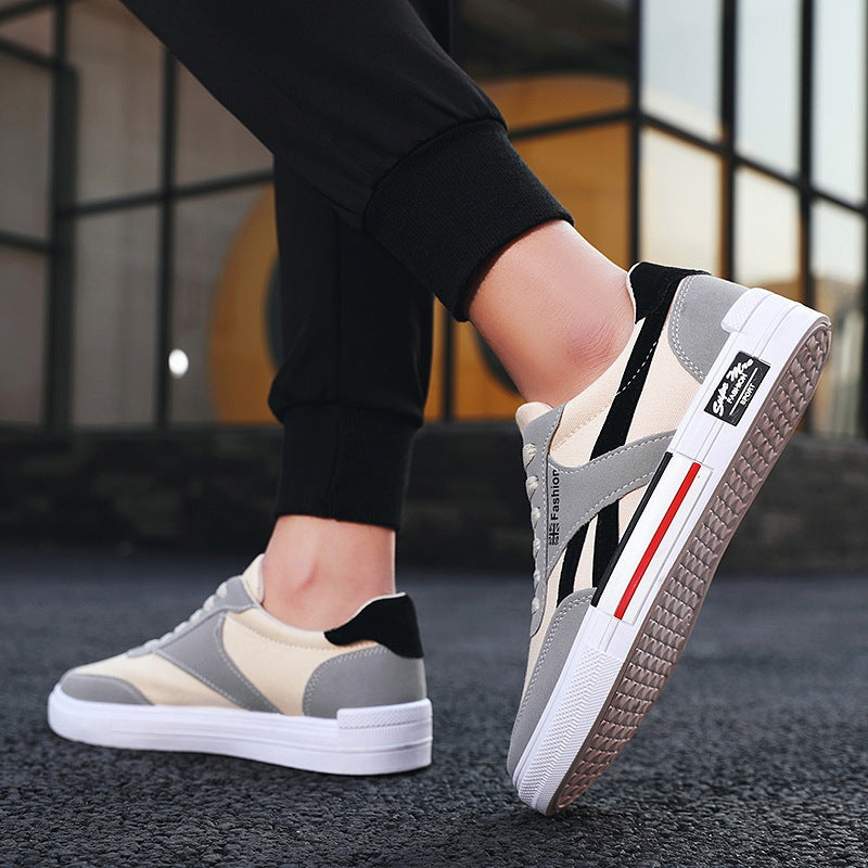 Stylish beige and gray sneakers with black accents from FashionRay on an urban street.