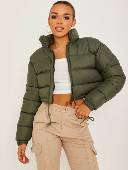 Woman in cropped green puffer jacket, white crop top, and beige cargo pants, FashionRay style