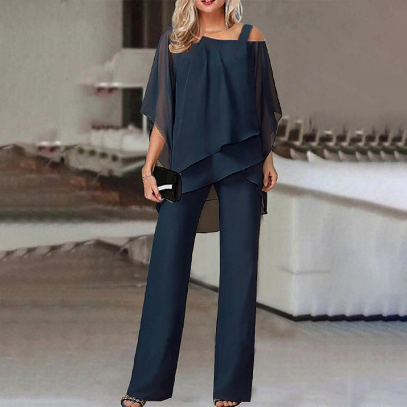 Woman modeling navy blue chiffon layered pantsuit, holding a clutch, FashionRay style