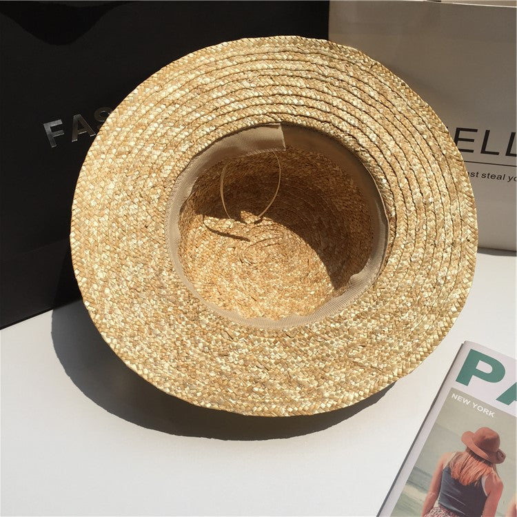 FashionRay woven straw hat on table, stylish summer accessory in natural light