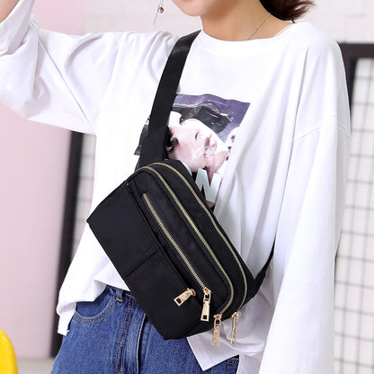 Woman in casual FashionRay style wears graphic white tee, crossbody black bag with zippers