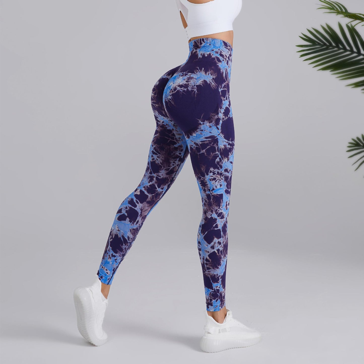 Woman modeling blue tie-dye high-waisted leggings and white crop top, FashionRay activewear