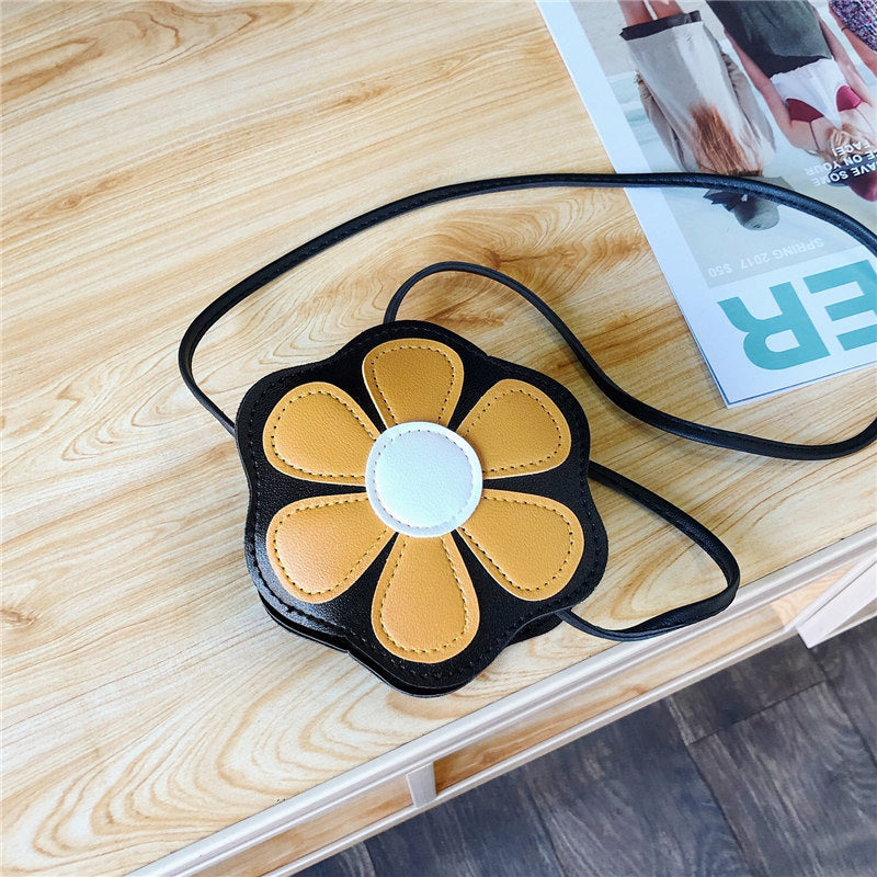 FashionRay flower-shaped crossbody bag with yellow petals on a wooden table