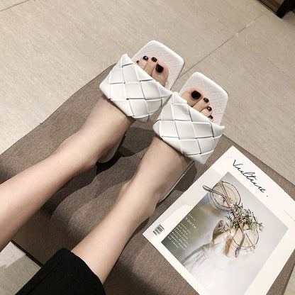 Woman wearing FashionRay white woven slide sandals, sitting indoors with fashion magazine