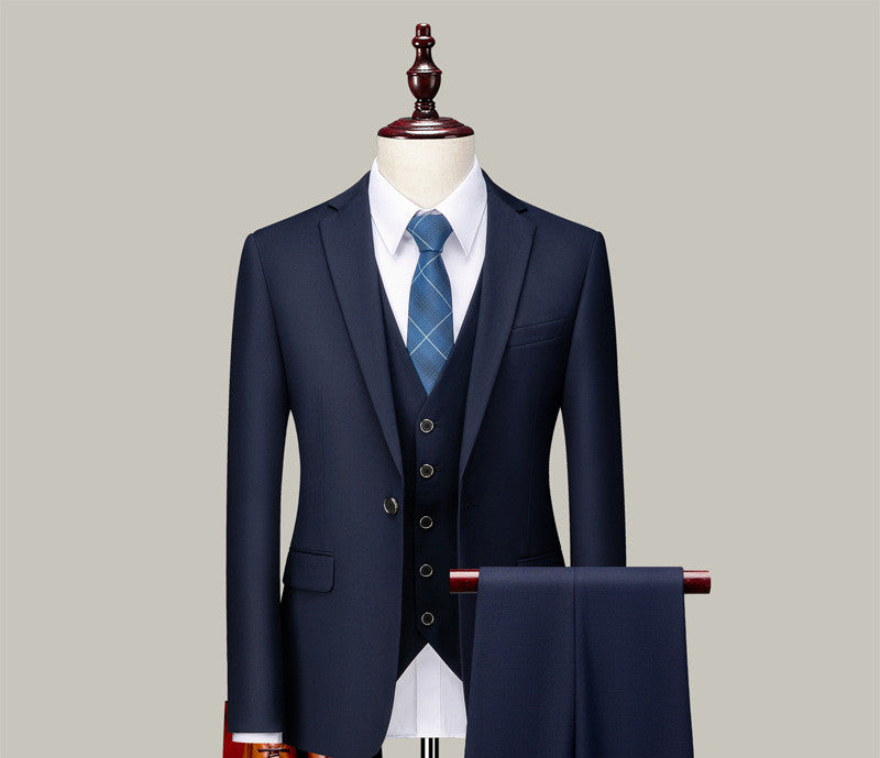 Navy blue three-piece suit with white shirt and blue plaid tie on mannequin, FashionRay style