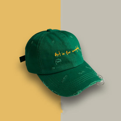 Green distressed baseball cap with yellow 'Art is for everybody' embroidery and a silver ring, trendy accessory from FashionRay.