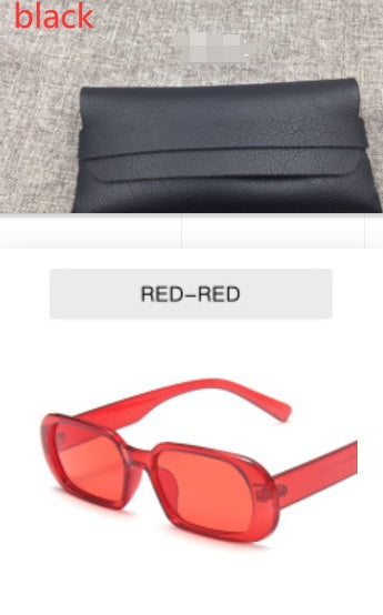 Black leather clutch on fabric surface and red rectangle sunglasses with FashionRay style.
