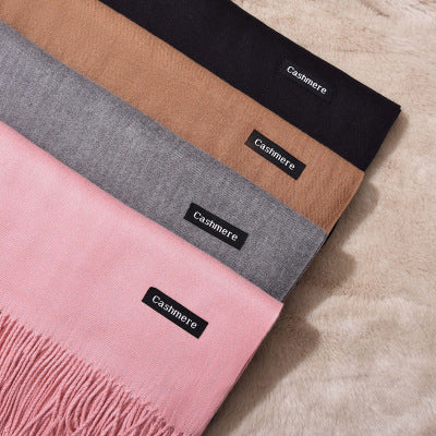 Assorted FashionRay cashmere scarves in pink, gray, camel, and black on soft fabric.