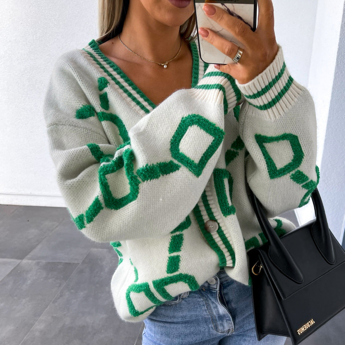 Woman wearing a white and green cardigan, light jeans, and holding a black handbag, FashionRay