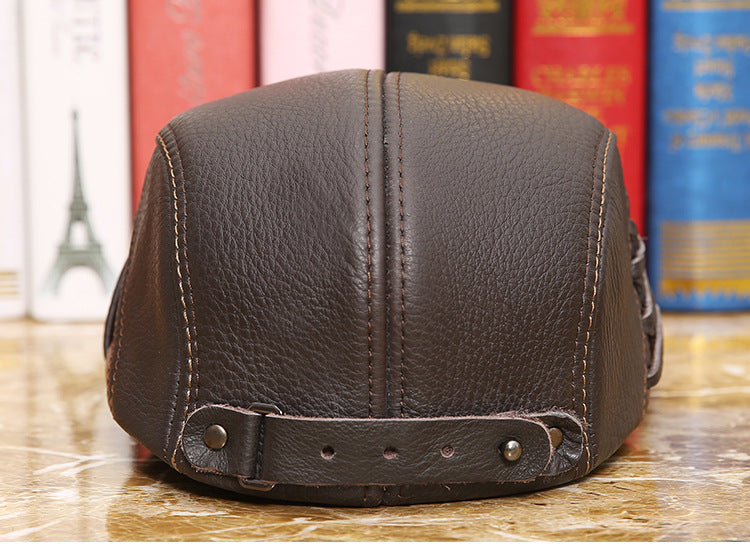 Brown leather flat cap with adjustable strap, FashionRay accessory on marble surface, books behind