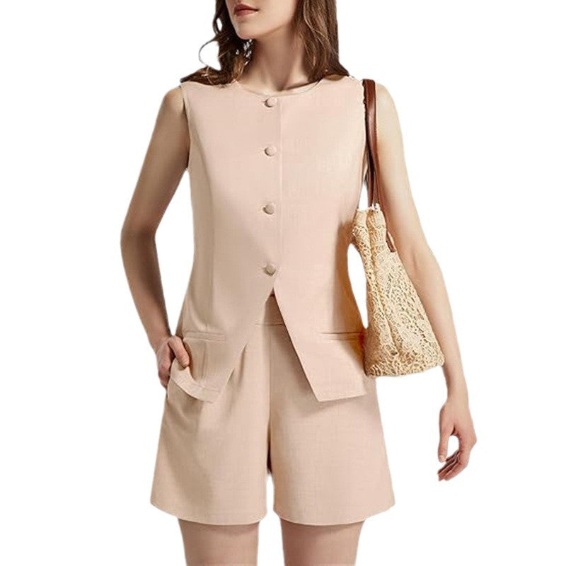 Woman in sleeveless beige shorts suit with buttons, carrying a lace shoulder bag, FashionRay style