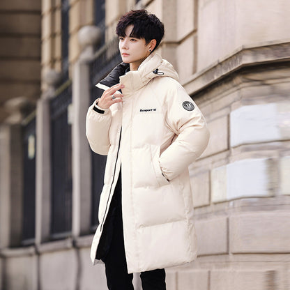 Man in a stylish beige puffer coat with hood standing outdoors, FashionRay trendy winter wear