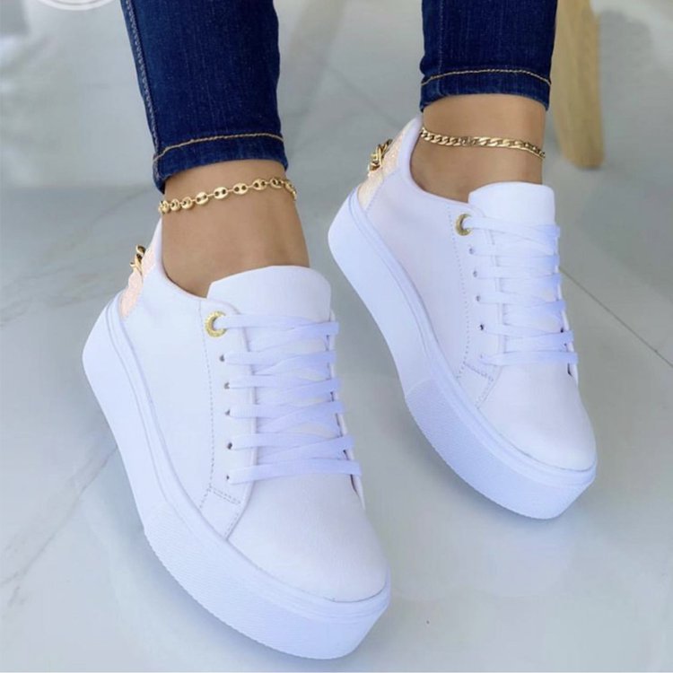 White platform sneakers with gold accents, paired with jeans and gold anklets, FashionRay style