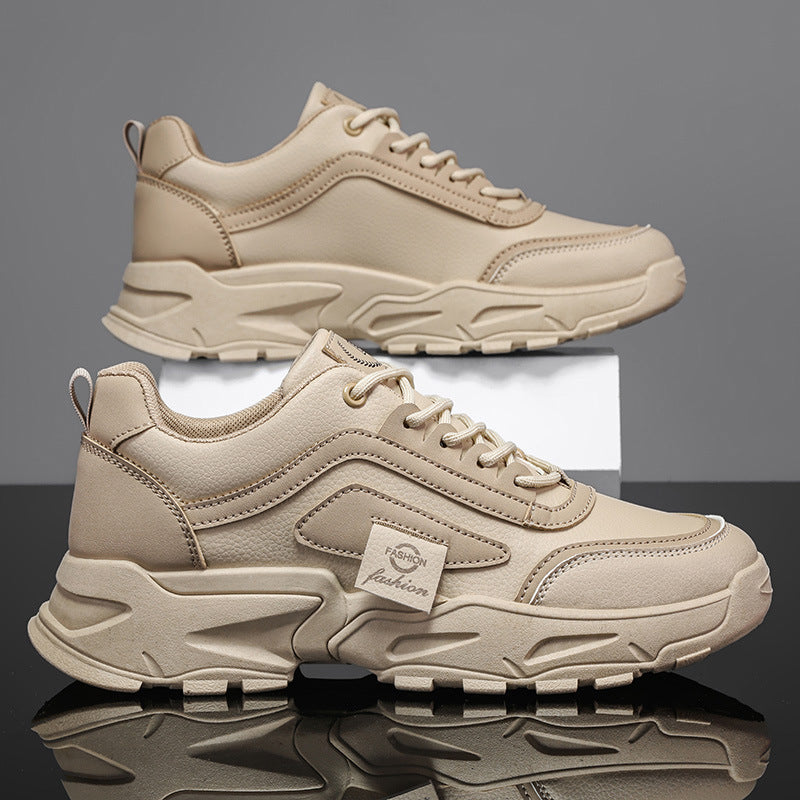 Beige chunky sneakers with thick soles, showcased on a reflective surface, FashionRay style
