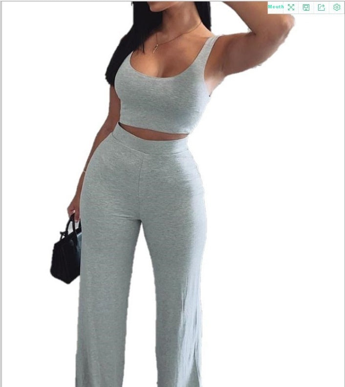 Woman wearing a light gray sleeveless crop top and high-waist pants set from FashionRay