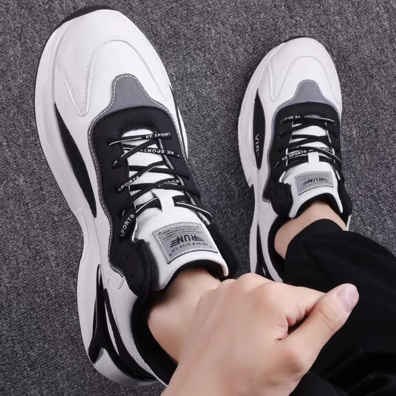 Trendy black and white sneakers on feet, FashionRay modern casual footwear, gray carpet background