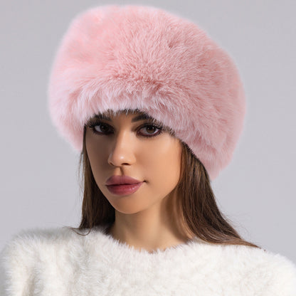 Woman wearing a fluffy pink faux fur hat and white sweater, stylish winter fashion from FashionRay