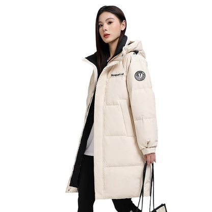 Woman in white puffer coat with hood holding bag, FashionRay trendy winter outfit