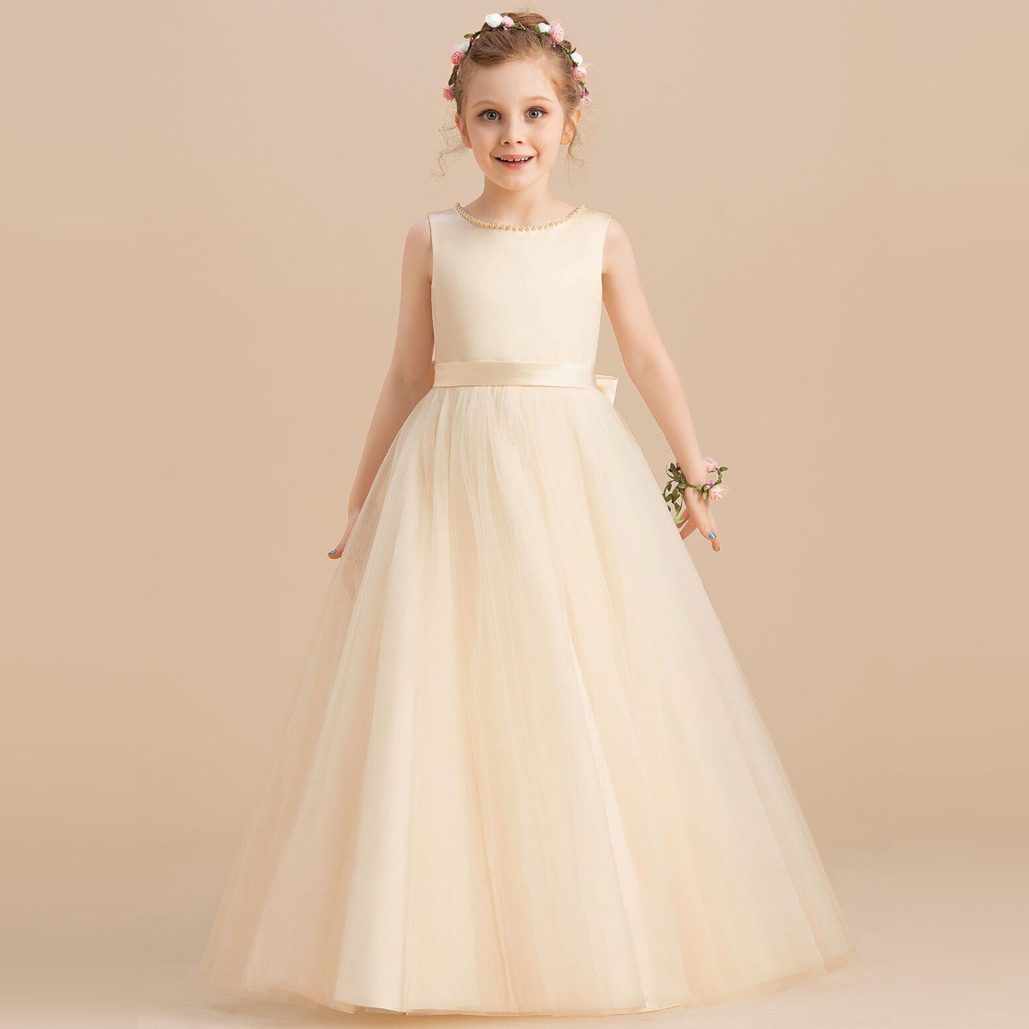 Girl in an elegant ivory tulle dress with floral headband, showcasing FashionRay style