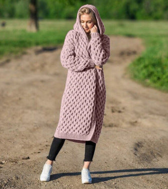 Woman outdoors in a pink knit hooded cardigan, black pants, and white sneakers, FashionRay style