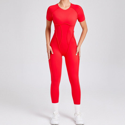 Woman modeling bold red short sleeve jumpsuit with contour seams, white sneakers, FashionRay style