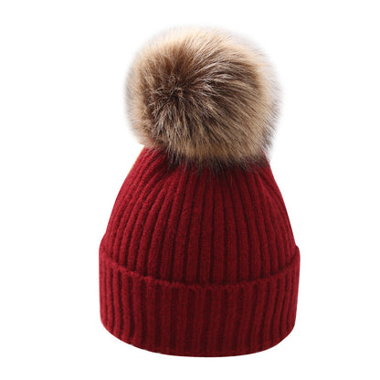 Red knit beanie with faux fur pom pom, trendy winter accessory at FashionRay