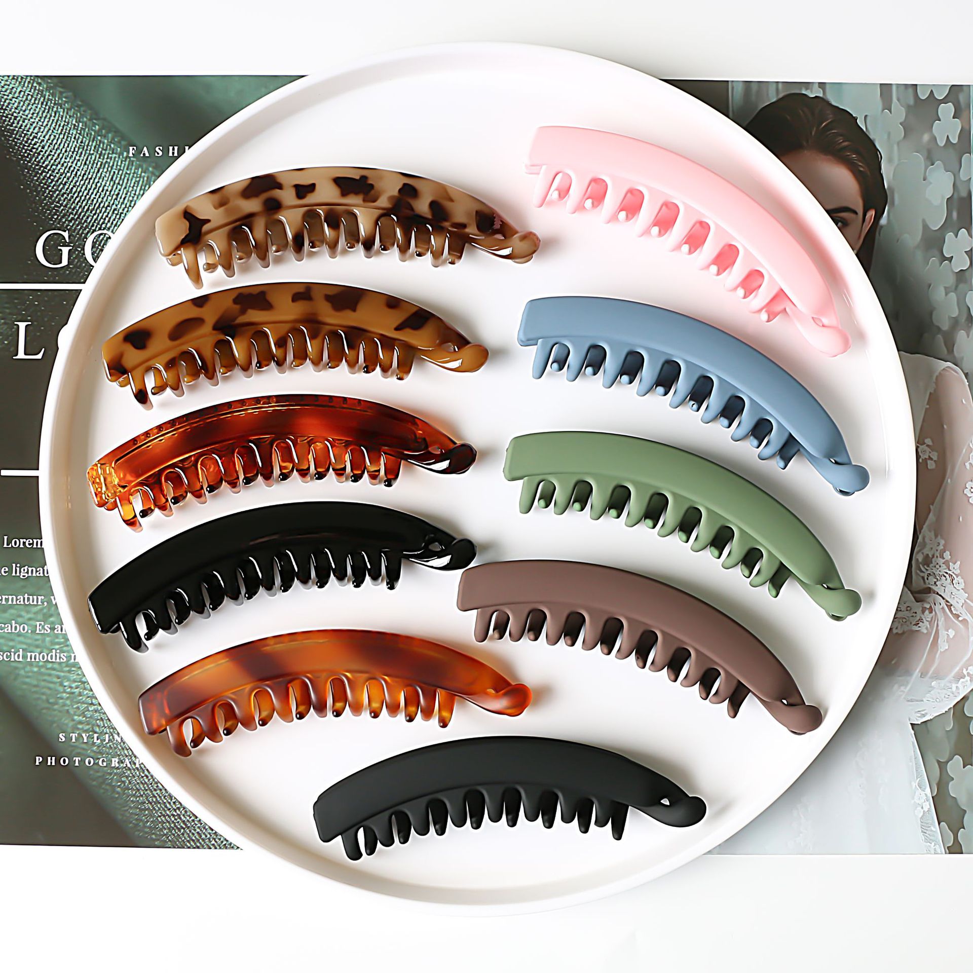 Assorted large hair claws in trendy colors and patterns on a white plate, FashionRay accessories