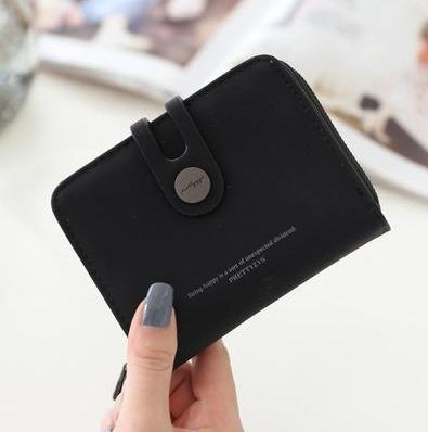 Woman holding a sleek black FashionRay wallet with snap closure and stylish design