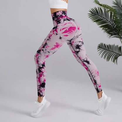 Woman in pink and black tie-dye leggings from FashionRay, white sneakers, indoor plant backdrop
